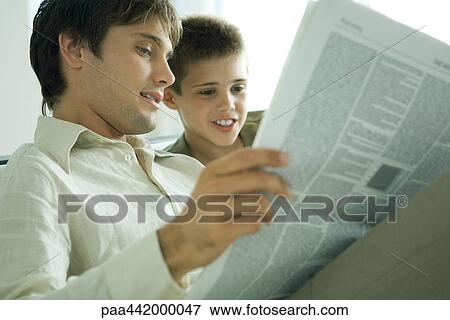 Father and son reading newspaper together View Large Photo Image Stock Photo - Father and son reading newspaper together. Fotosearch