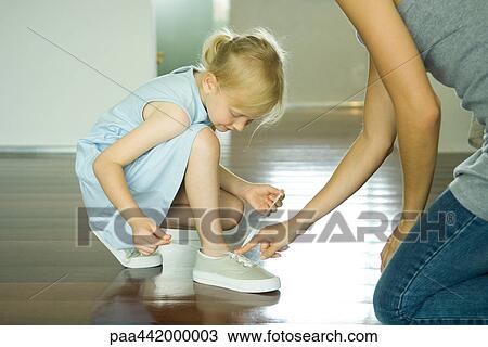 Mother and daughter tying girl's shoes together View Large Photo Image Stock Image - Mother and daughter tying girl's shoes together. Fotosearch