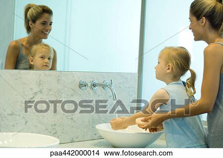 Mother and daughter washing hands together View Large Photo Image Picture - Mother and daughter washing hands together. Fotosearch