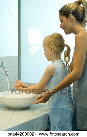 Mother and daughter washing hands together View Large Photo Image Stock Photo - Mother and daughter washing hands together. Fotosearch