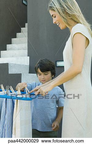Mother and son hanging out laundry to dry View Large Photo Image Stock Photo - Mother and son hanging out laundry to dry. Fotosearch