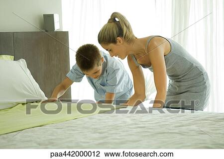 Mother and son making bed together View Large Photo Image Stock Image - Mother and son making bed together. Fotosearch