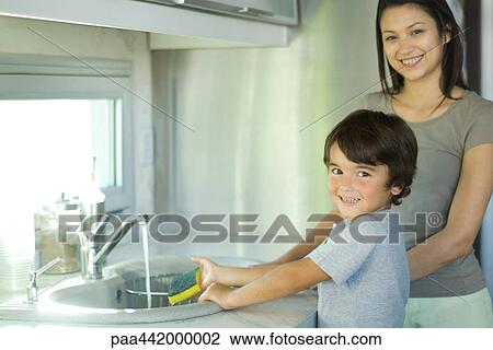 Mother and son washing dishes together View Large Photo Image Stock Image - Mother and son washing dishes together. Fotosearch