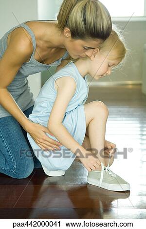 Mother watching daughter ties shoe laces View Large Photo Image Stock Image - Mother watching daughter ties shoe laces. Fotosearch