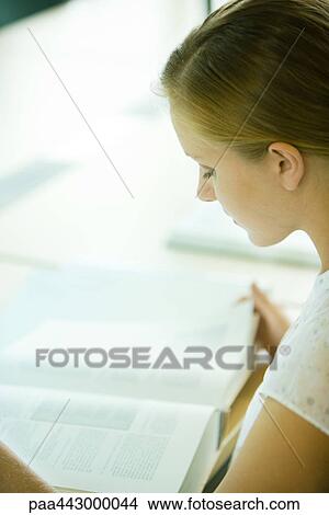 Female college student sitting at table in library, studying View Large Photo Image Picture - Female college student sitting at table in library, studying. Fotosearch