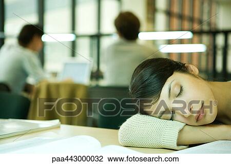 Female college student sitting at table in library, resting head on table View Large Photo Image Stock Image - Female college student sitting at table in library, resting head on table. Fotosearch