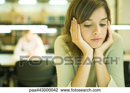 Female college student sitting at table in library, studying View Large Photo Image Stock Image - Female college student sitting at table in library, studying. Fotosearch