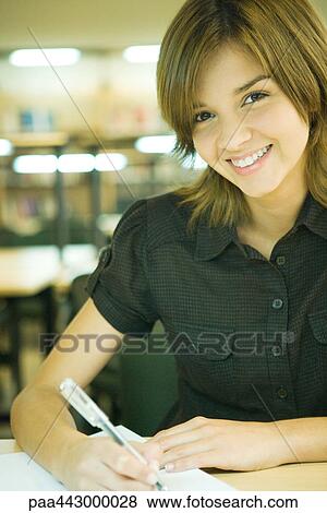 Female college student sitting at table in library, studying View Large Photo Image Stock Photo - Female college student sitting at table in library, studying. Fotosearch