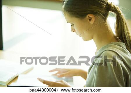 Female college student sitting at table in library, studying View Large Photo Image Stock Photo - Female college student sitting at table in library, studying. Fotosearch
