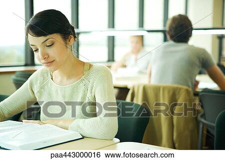 Female college student sitting at table in library, studying View Large Photo Image Stock Photograph - Female college student sitting at table in library, studying. Fotosearch