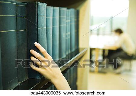 Female hand taking book from shelf in library View Large Photo Image Stock Photography - Female hand taking book from shelf in library. Fotosearch