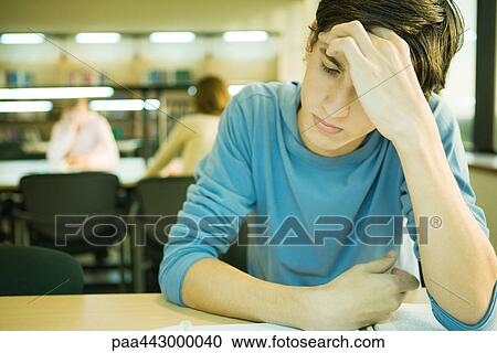 Male college student sitting in library, studying View Large Photo Image Stock Image - Male college student sitting in library, studying. Fotosearch
