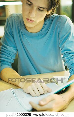Male college student sitting in library, studying View Large Photo Image Stock Photo - Male college student sitting in library, studying. Fotosearch