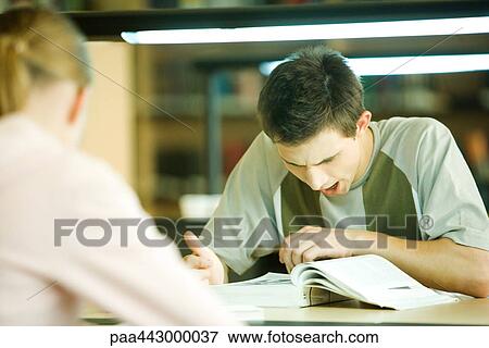 Male college student sitting in library, studying and yawning View Large Photo Image Stock Photo - Male college student sitting in library, studying and yawning. Fotosearch