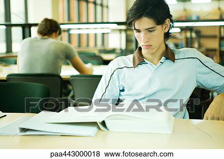 Male college student sitting library, studying View Large Photo Image Stock Photo - Male college student sitting library, studying. Fotosearch