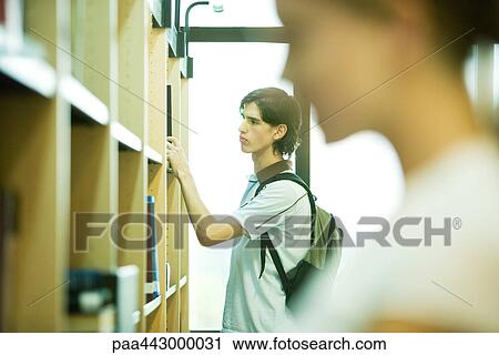 Students looking at shelves in college library View Large Photo Image Stock Image - Students looking at shelves in college library. Fotosearch