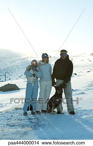 Skiers standing on snowy slope with two dogs View Large Photo Image Picture - Skiers standing on snowy slope with two dogs. Fotosearch
