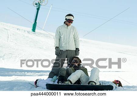 Snowboarders lying in snow, looking up at friend View Large Photo Image Stock Image - Snowboarders lying in snow, looking up at friend. Fotosearch