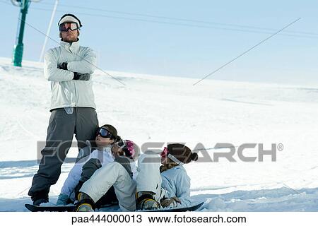 Snowboarders lying in snow, looking up at friend View Large Photo Image Stock Image - Snowboarders lying in snow, looking up at friend. Fotosearch