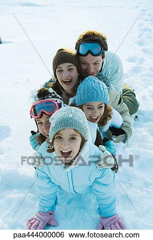 Young friends dressed in ski clothes, sitting in snow, portrait View Large Photo Image Stock Photograph - Young friends dressed in ski clothes, sitting in snow, portrait. Fotosearch