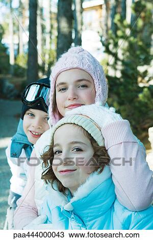 Stock Image - Young friends in ski clothing, looking at camera. Fotosearch