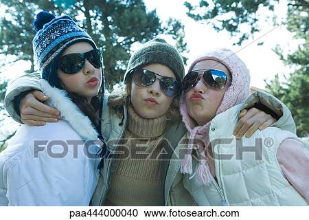 Young friends in winter clothing, puckering at camera, portrait View Large Photo Image Stock Image - Young friends in winter clothing, puckering at camera, portrait. Fotosearch
