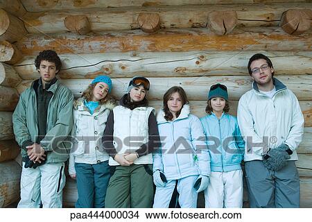 Young friends standing by log cabin, portrait View Large Photo Image Picture - Young friends standing by log cabin, portrait. Fotosearch