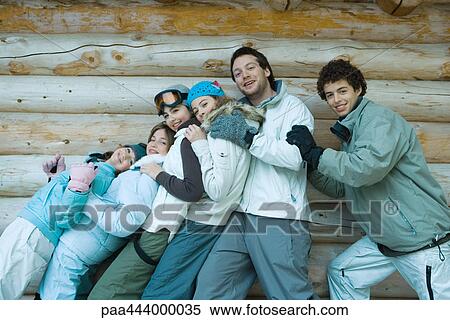 Young friends standing by log cabin, portrait View Large Photo Image Stock Photography - Young friends standing by log cabin, portrait. Fotosearch