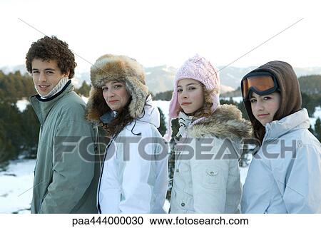 Young friends standing in snowy landscape, portrait View Large Photo Image Stock Image - Young friends standing in snowy landscape, portrait. Fotosearch