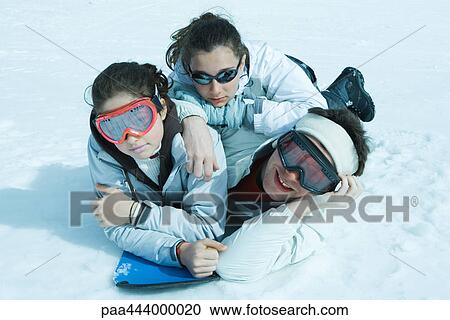 Young skiers lying in snow, portrait View Large Photo Image Stock Image - Young skiers lying in snow, portrait. Fotosearch