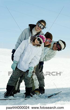 Young skiers standing on ski slope, leaning to the side, full length portrait View Large Photo Image Picture - Young skiers standing on ski slope, leaning to the side, full length portrait . Fotosearch