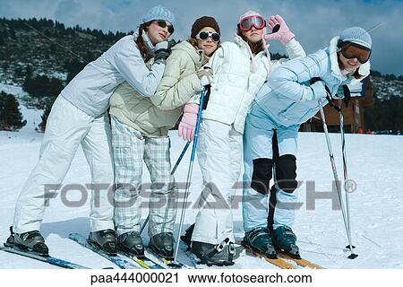 Young skiers standing on ski slope, full length portrait View Large Photo Image Stock Image - Young skiers standing on ski slope, full length portrait . Fotosearch