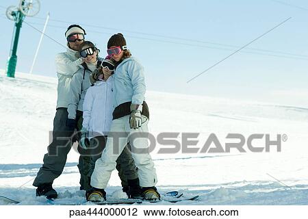 Young snowboarders standing together, full length portrait View Large Photo Image Stock Image - Young snowboarders standing together, full length portrait. Fotosearch