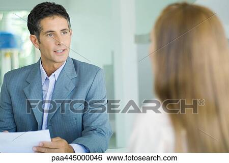 Businessman speaking to young woman View Large Photo Image Stock Photograph - Businessman speaking to young woman. Fotosearch