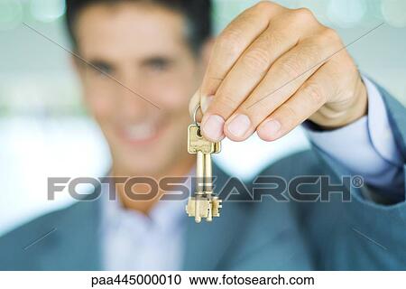 Man in suit holding up keys, focus on hand holding keys in foreground View Large Photo Image Stock Image - Man in suit holding up keys, focus on hand holding keys in foreground. Fotosearch