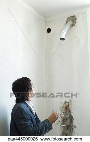 Man in suit inspecting air duct in home interior View Large Photo Image Stock Photograph - Man in suit inspecting air duct in home interior. Fotosearch