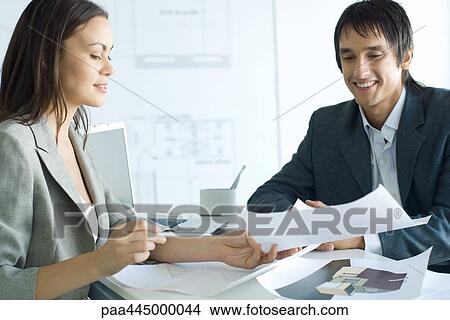 Woman and man sitting across table in architecture firm View Large Photo Image Picture - Woman and man sitting across table in architecture firm. Fotosearch