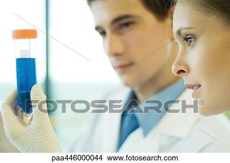 Young male and female lab workers, holding up test tube View Large Photo Image Picture - Young male and female lab workers, holding up test tube. Fotosearch