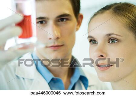 Young male and female lab workers, holding up test tube View Large Photo Image Stock Photograph - Young male and female lab workers, holding up test tube. Fotosearch
