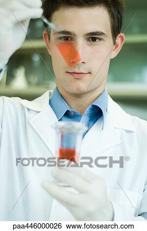 Young male lab worker holding up microscope slide and beaker View Large Photo Image Stock Photograph - Young male lab worker holding up microscope slide and beaker. Fotosearch