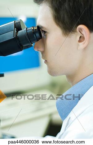 Stock Photograph - Young male scientist using microscope. Fotosearch