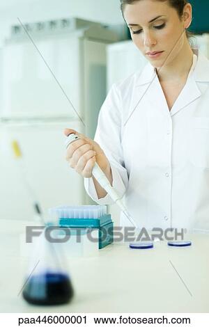 Stock Image - Young woman working in scientific laboratory. Fotosearch