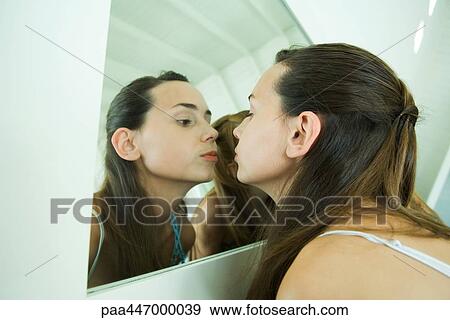 Teenage girl looking at self in mirror, kissing her reflection View Large Photo Image Stock Photo - Teenage girl looking at self in mirror, kissing her reflection. Fotosearch