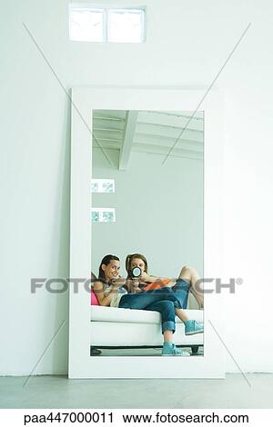 Two young friends putting on makeup, reflection in mirror, mid-distance View Large Photo Image Stock Image - Two young friends putting on makeup, reflection in mirror, mid-distance. Fotosearch