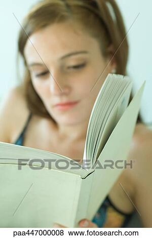 Young woman reading, focus on book View Large Photo Image Stock Photo - Young woman reading, focus on book. Fotosearch