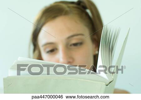 Young woman reading, focus on book View Large Photo Image Stock Photograph - Young woman reading, focus on book. Fotosearch