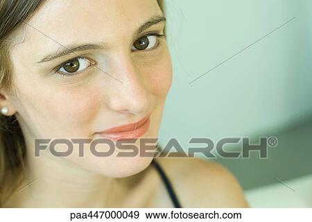 Young woman smiling at camera, portrait, close-up View Large Photo Image Stock Photo - Young woman smiling at camera, portrait, close-up. Fotosearch