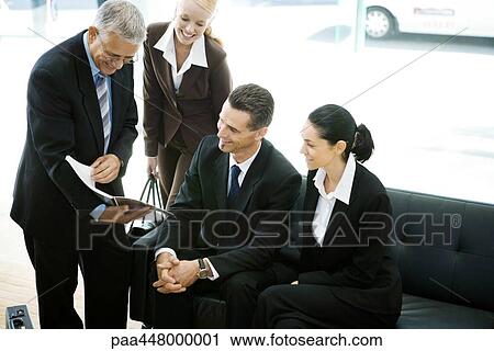 Business associates looking at booklet View Large Photo Image Stock Image - Business associates looking at booklet. Fotosearch