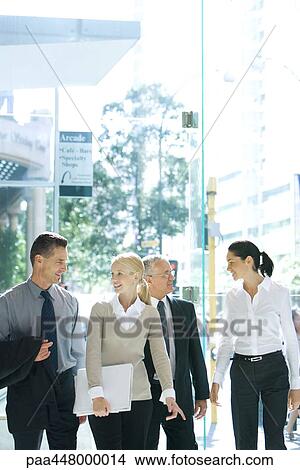 Picture - Business associates walking on sidewalk, chatting. Fotosearch