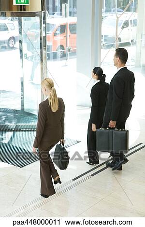 Business associates with briefcases exiting office lobby View Large Photo Image Stock Image - Business associates with briefcases exiting office lobby. Fotosearch